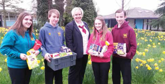 A group of people holding baskets full of Easter eggs.