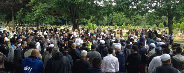 A group of people standing in a circle paying their respects.