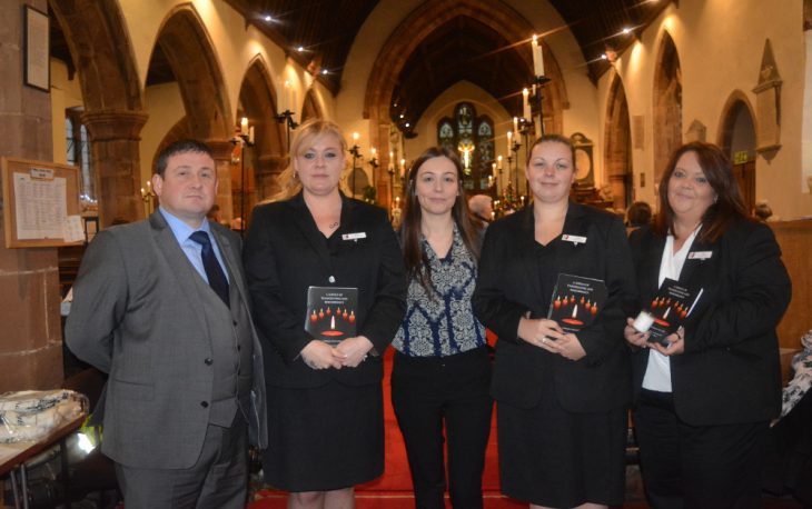 5 people stand inside St Edburghas Church for the Christmas remembrance service.