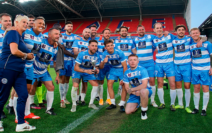 A group of people in football kits posing for a photo