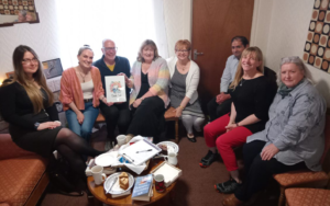 People sitting around in a semi-circle at event in Belfast Café Belfast. They are coming together to talk about death.