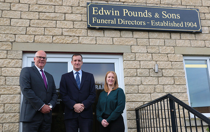 A group of people standing in front of Funeral service Edwin Pounds & Sons.