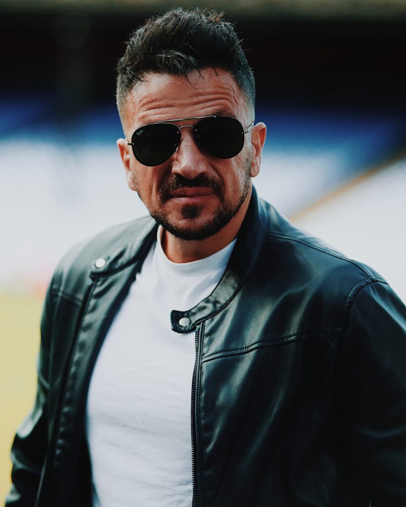 Peter Andre wearing a leather jacket and dark sunglasses. 